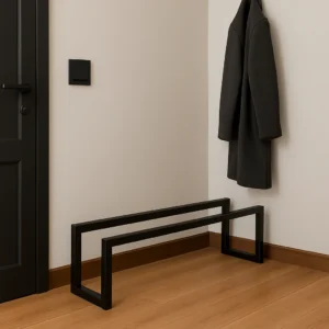 Metalowa półka na buty Nveria 80x20x20 ustawiona przy ścianie w przedpokoju, w minimalistycznym czarnym wykończeniu